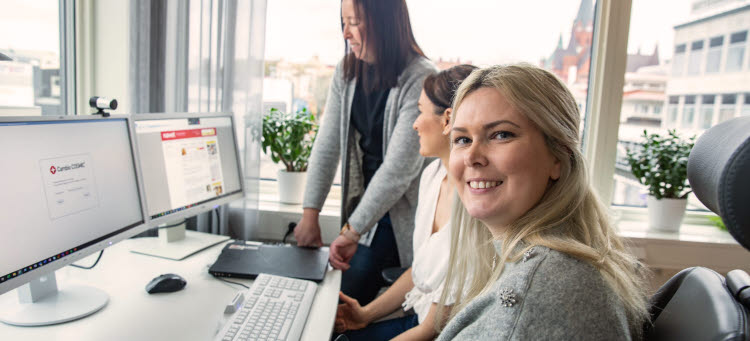 Tre personer vid skrivbord