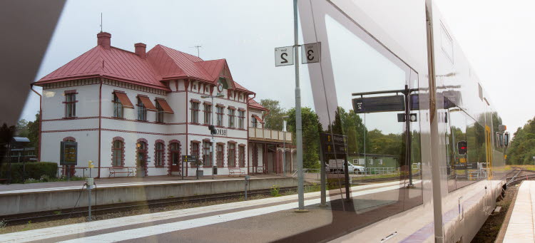 Bild på ett tåg och Berga stationshus.