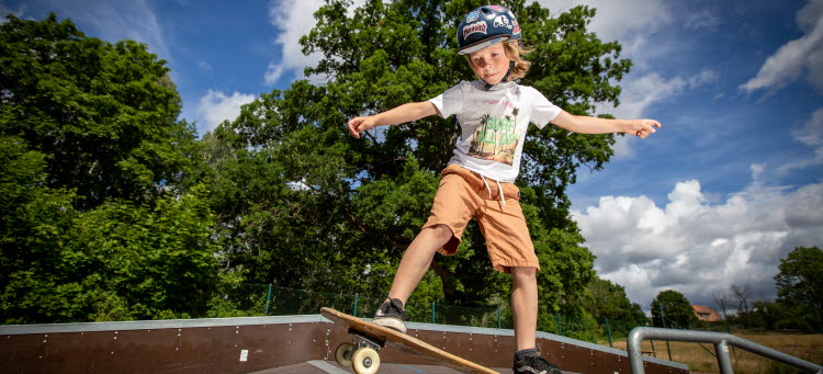 Ett barn åker skateboard.